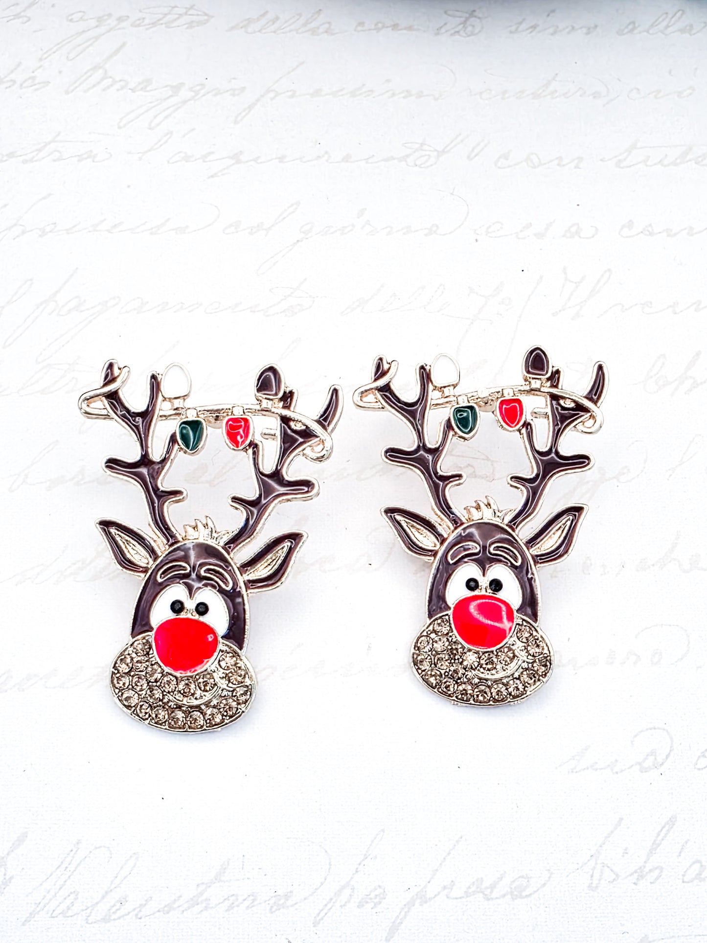 Pair of reindeer-shaped earrings with red noses on a white background