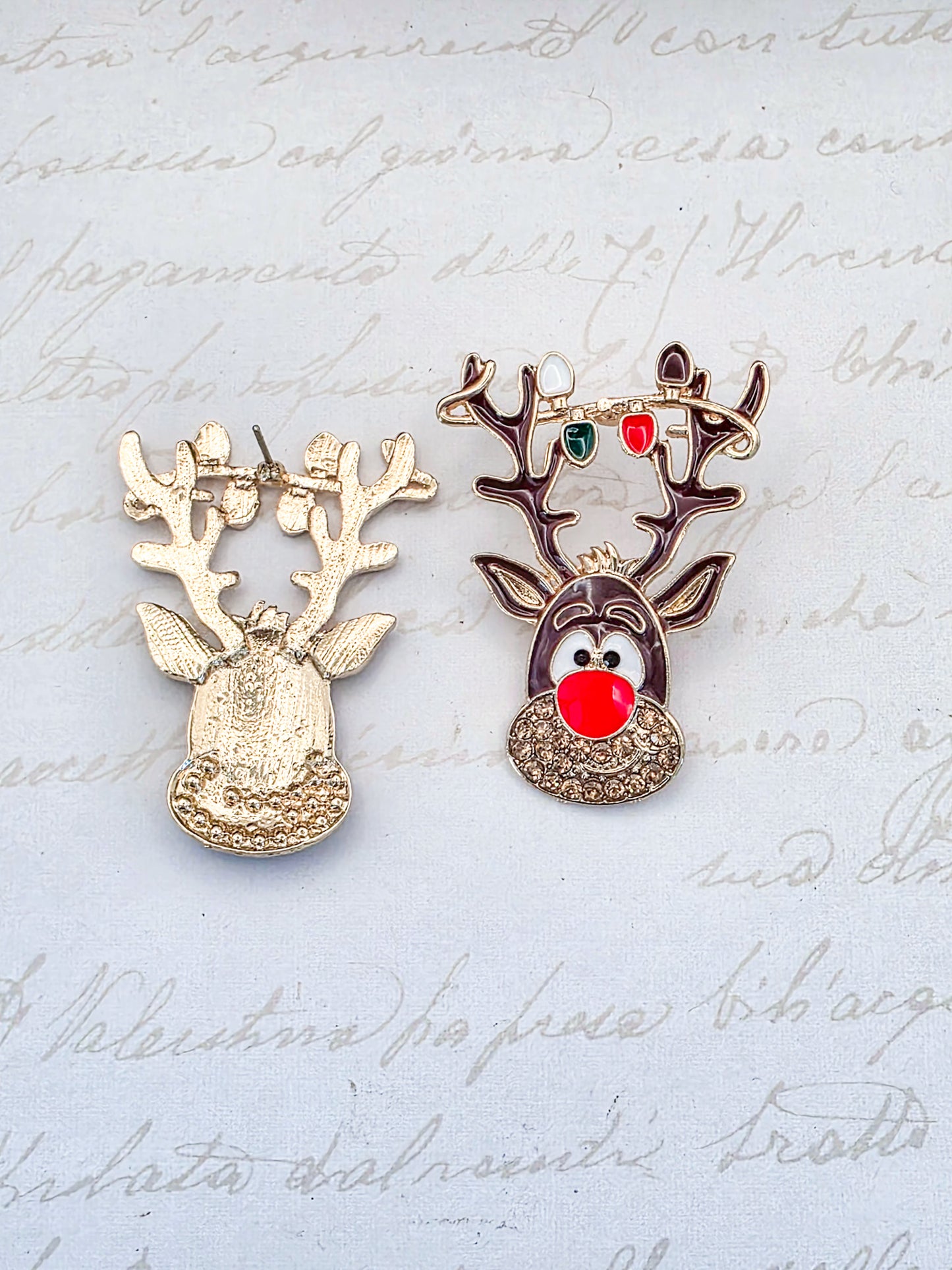 Two reindeer-shaped earrings on a paper background