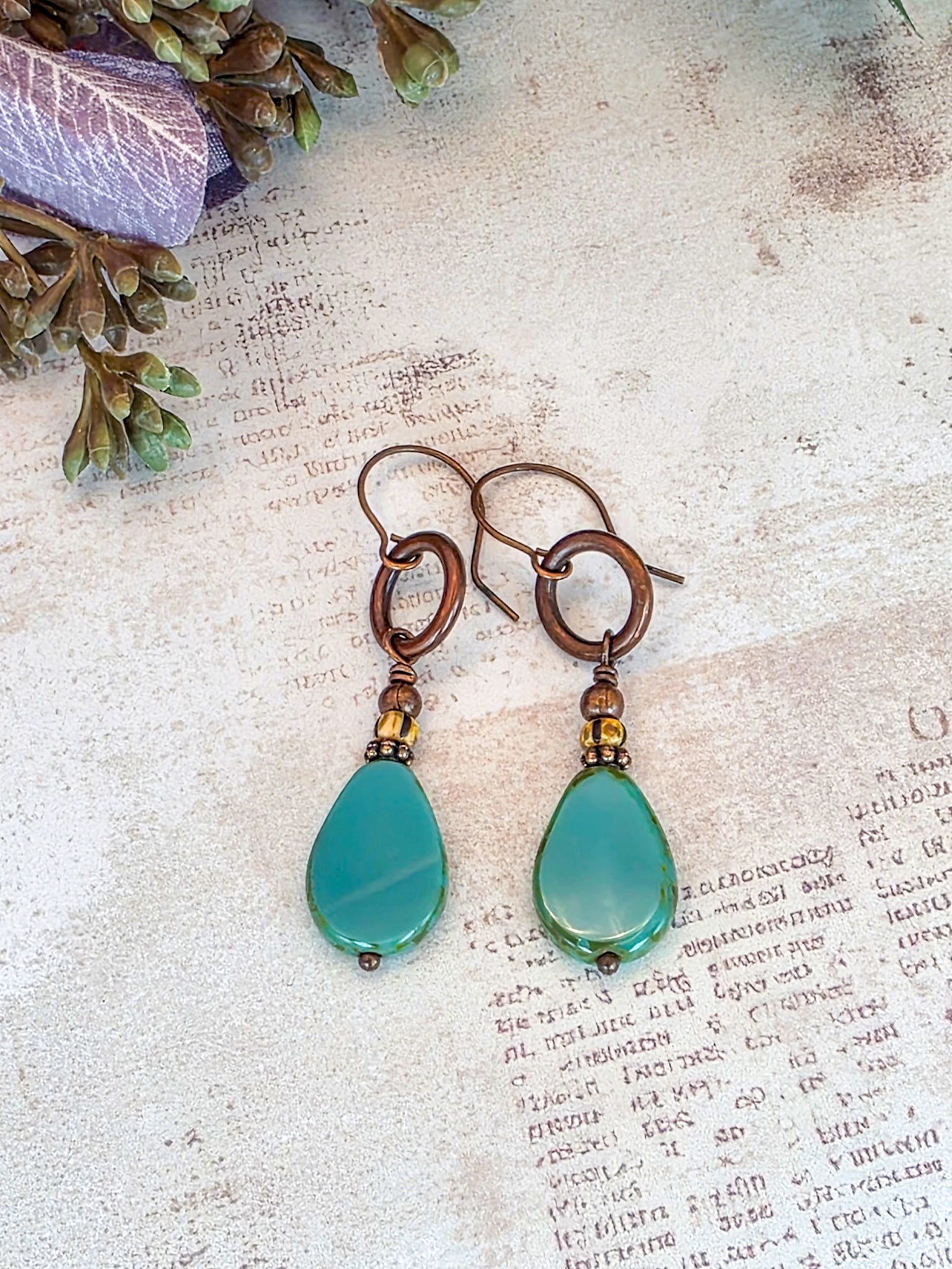 Handcrafted aqua Czech glass teardrop earrings with antiqued copper circles and brass accents.