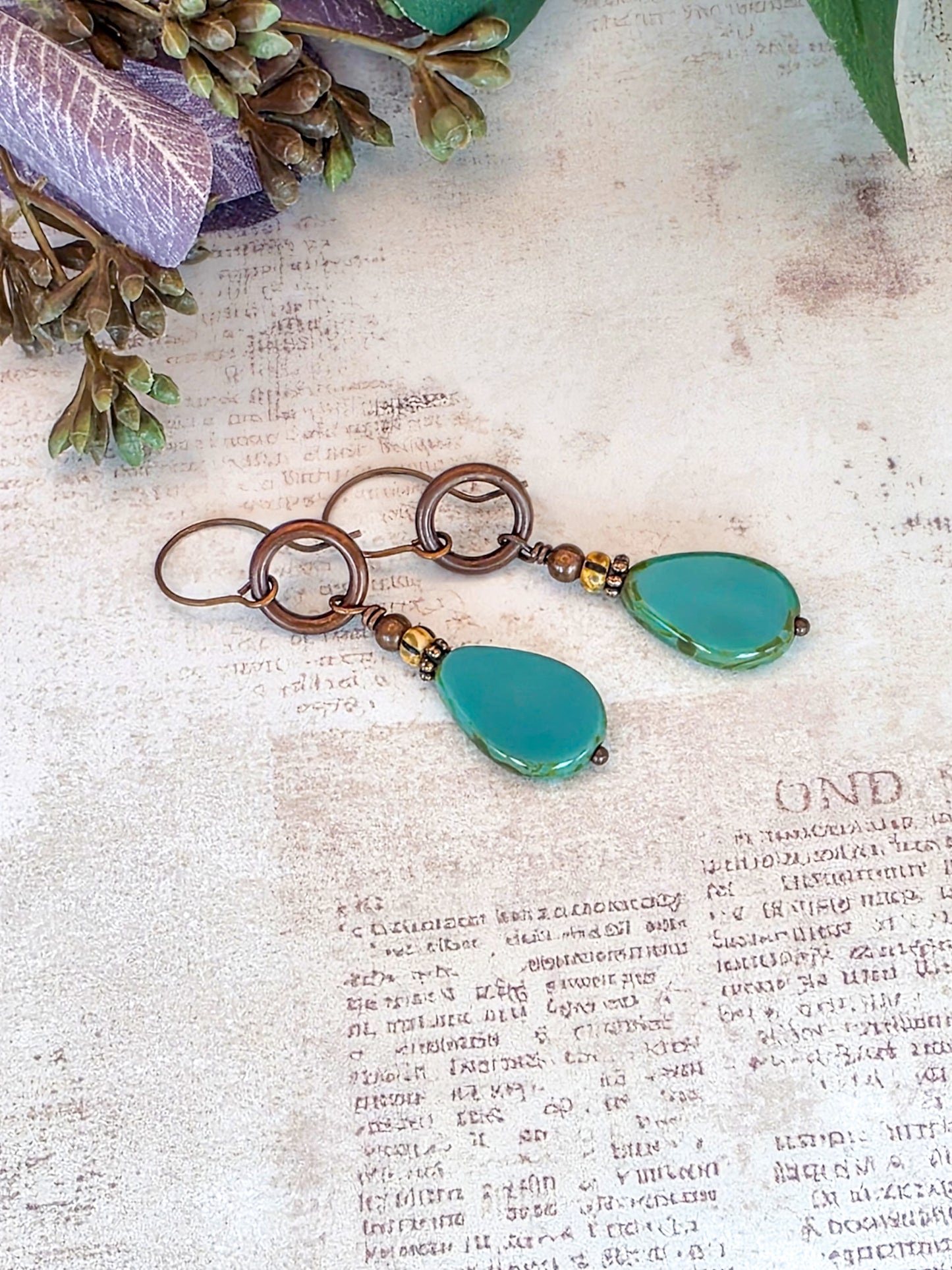 Handcrafted aqua Czech glass teardrop earrings with antiqued copper circles and brass accents.