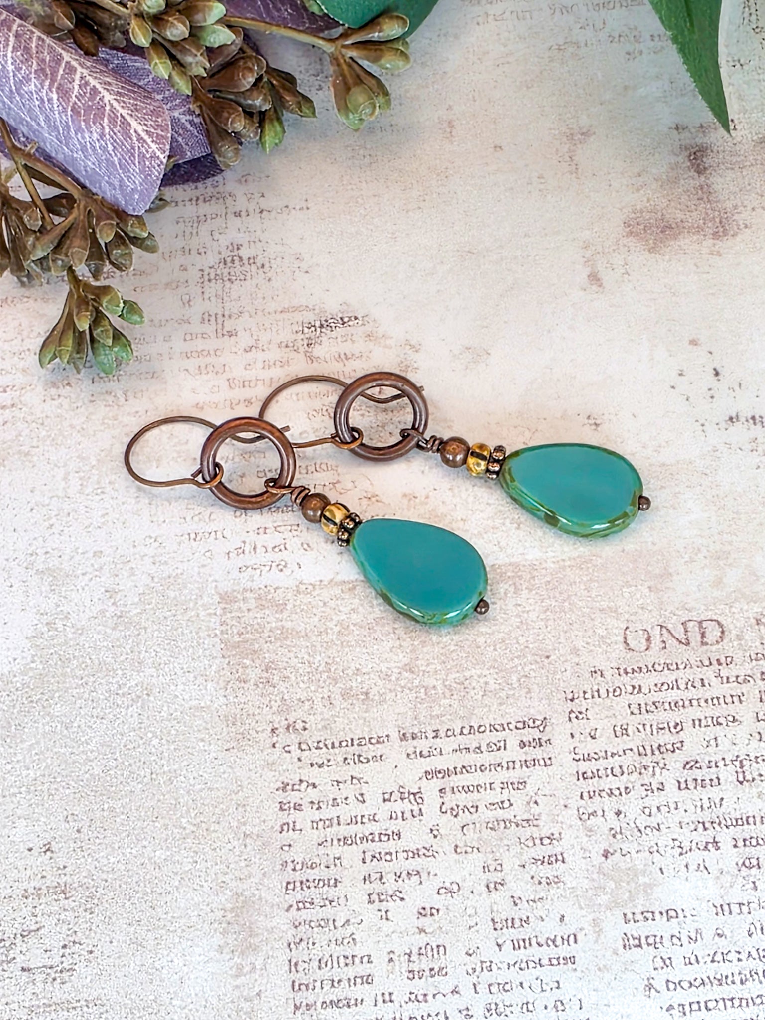 Handcrafted aqua Czech glass teardrop earrings with antiqued copper circles and brass accents.