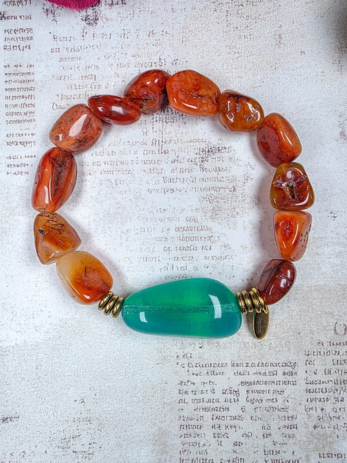 Carnelian beaded bracelet with large aqua Czech glass focal bead and brass accents