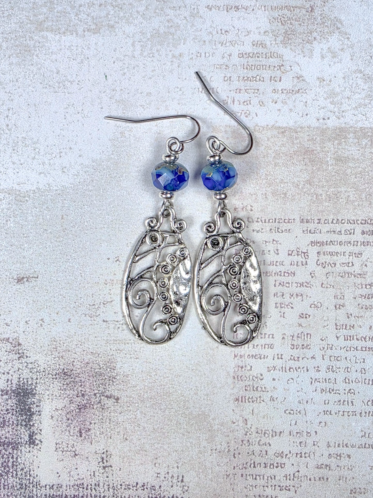 Blue Czech glass dangle earrings with silver scrollwork and stainless steel ear wires