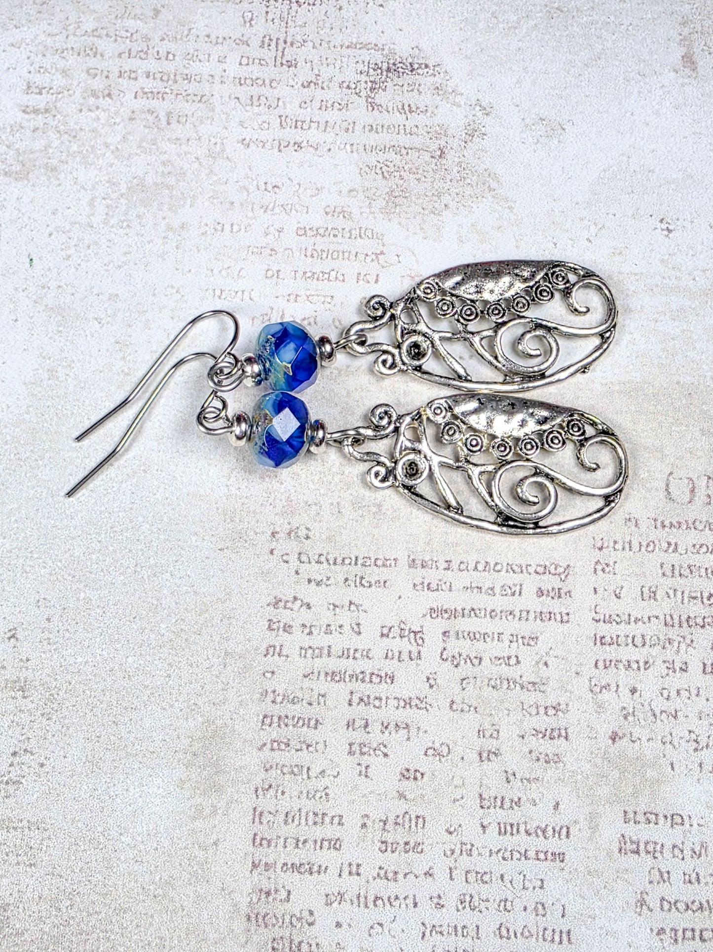 Blue Czech glass dangle earrings with silver scrollwork and stainless steel ear wires