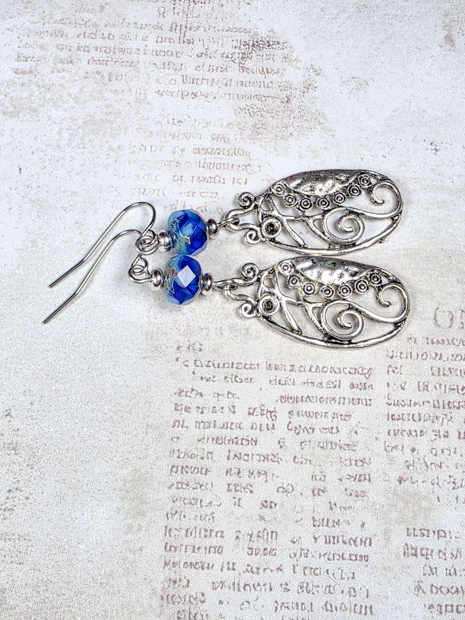 Blue Czech glass dangle earrings with silver scrollwork and stainless steel ear wires