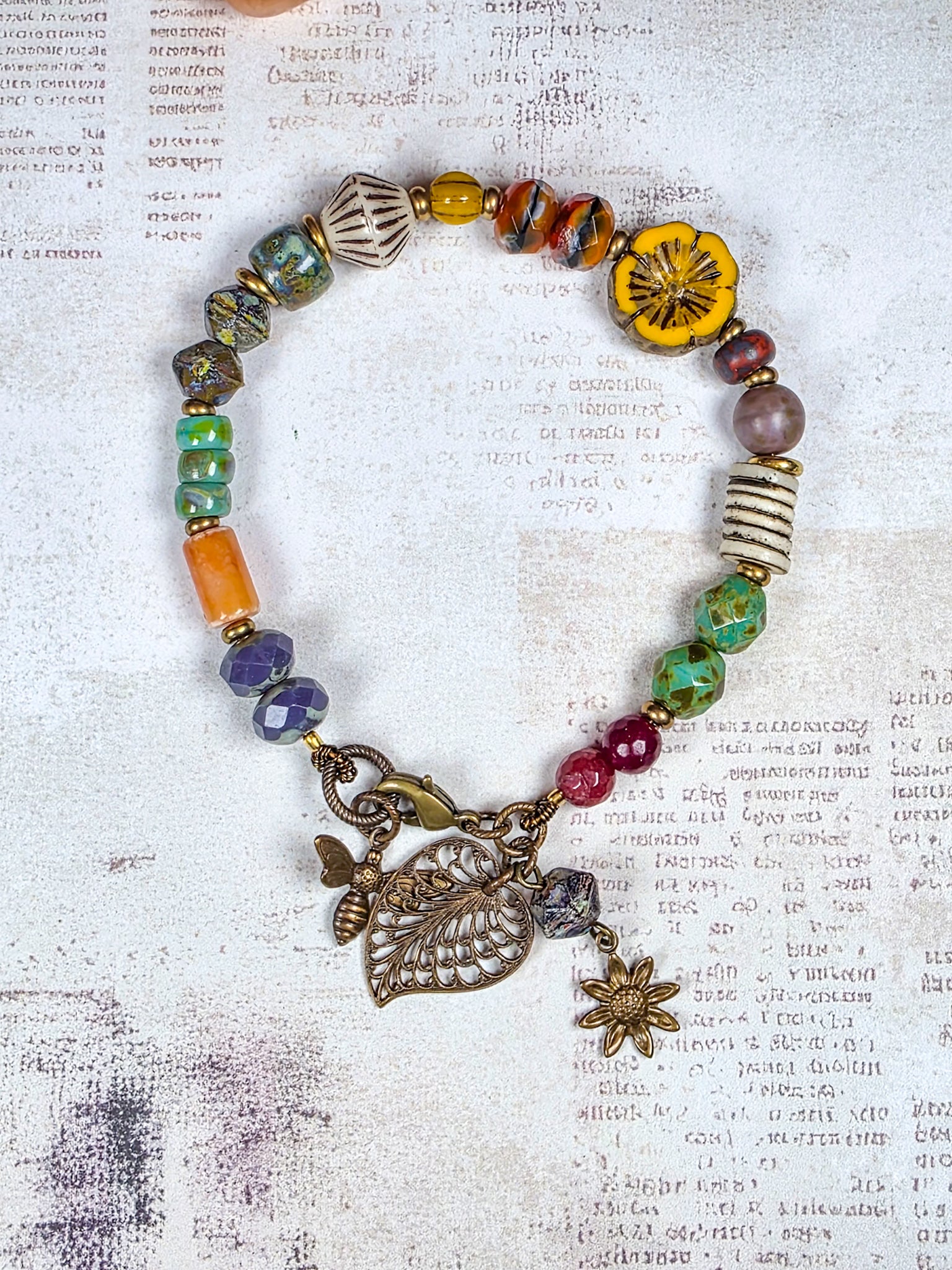 Colorful Czech glass bracelet with antiqued brass leaf flower and bee charms
