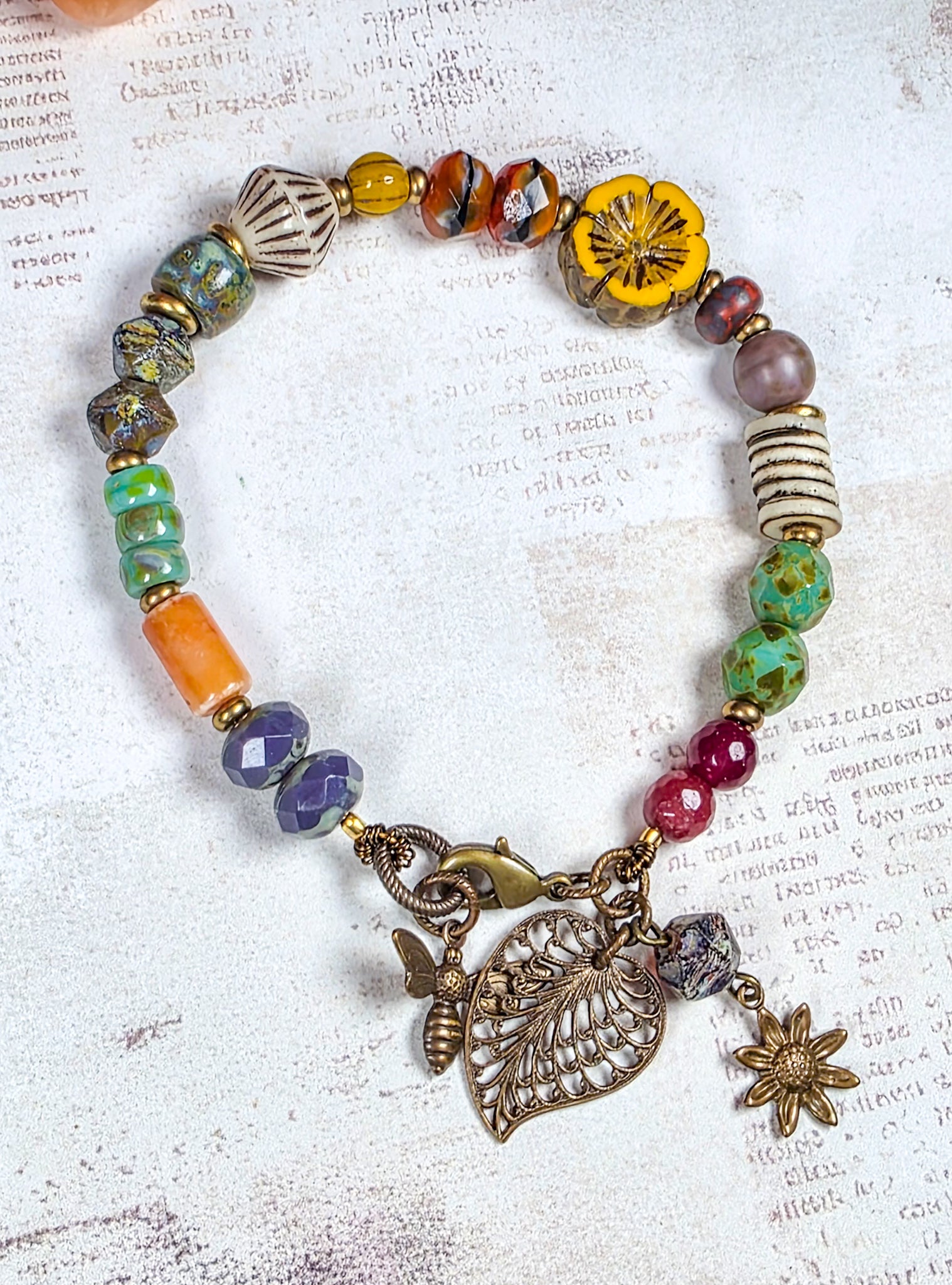 Colorful Czech glass bracelet with antiqued brass leaf flower and bee charms