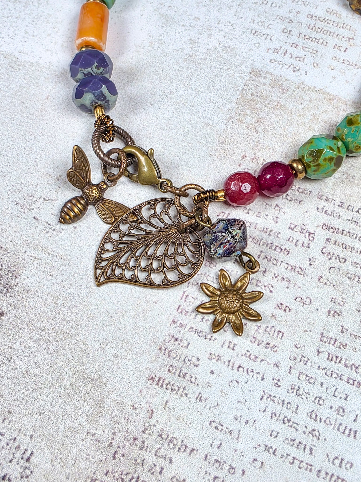 Colorful Czech glass bracelet with antiqued brass leaf flower and bee charms