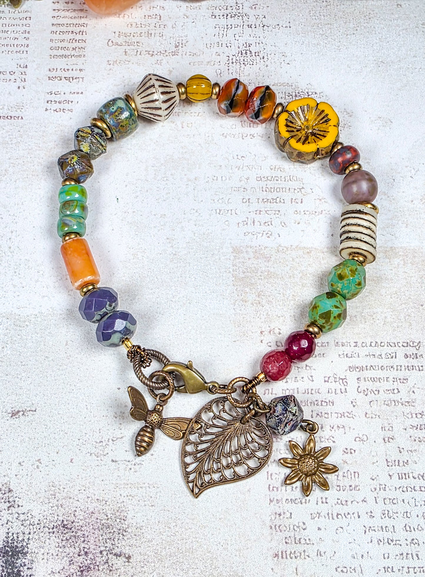 Colorful Czech glass bracelet with antiqued brass leaf flower and bee charms